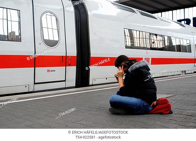 A Man sitting infront of a ICE and take a call