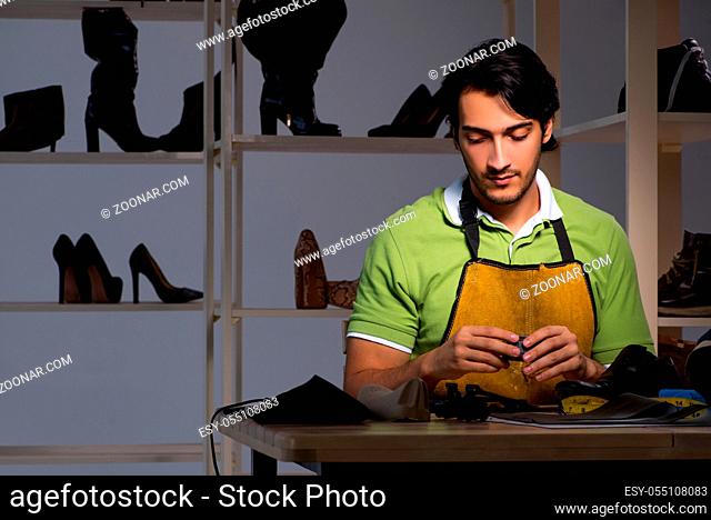 Young shoemaker in workshop at night