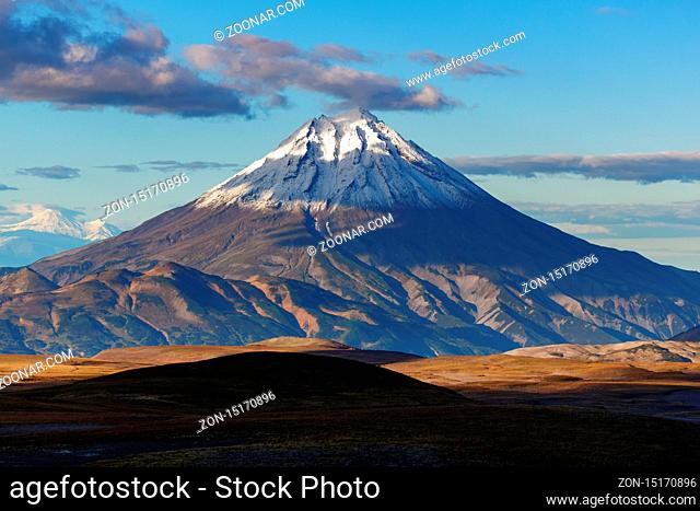 Autumn mountain landscape: scenery evening view of snow-capped cone of Vilyuchinsky Volcano on Kamchatka Peninsula. Journey to volcanoes and mountains - popular...