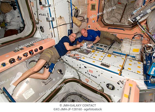 NASA astronaut Don Pettit (left) and European Space Agency astronaut Andre Kuipers, both Expedition 31 flight engineers, eat a snack in the Unity node of the...