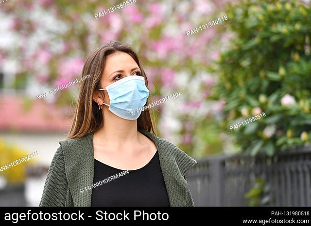 Topic image Corona: A young woman with protective mask, face mask, community mask walks on a walk on April 24th, 2020. | usage worldwide
