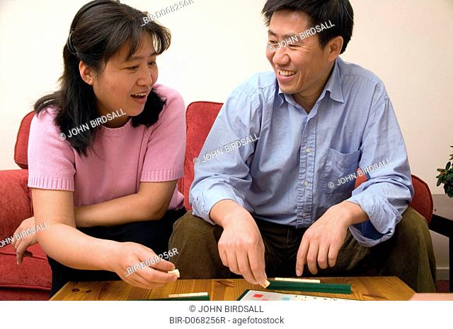 Couple playing a game of scrabble together at home