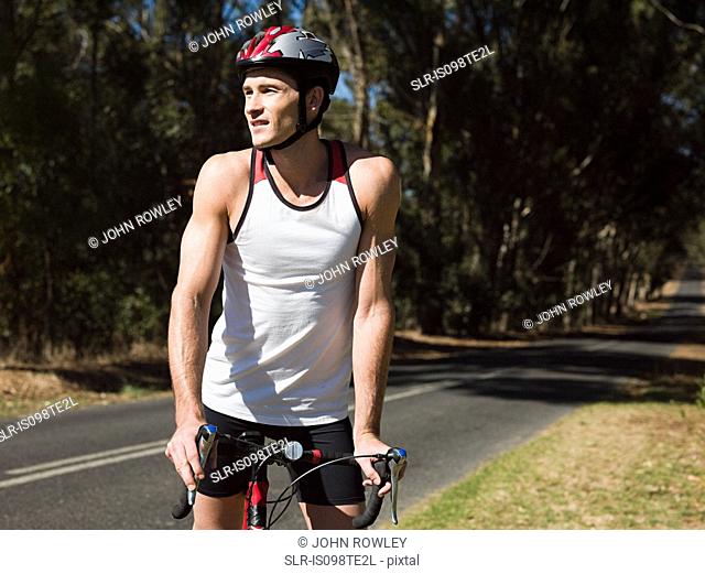 Young man cycling on road