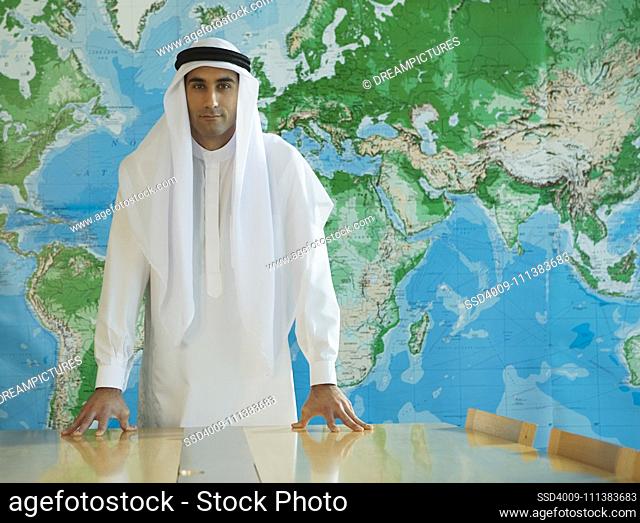 Serious Middle Eastern man in traditional clothing in conference room