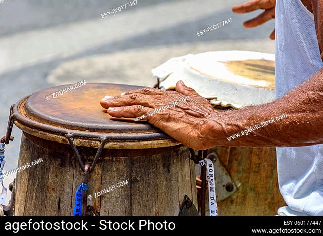 Musician playing a traditional Brazilian percussion instrument called atabaque during a capoeira performance on the streets of Pelourinho in Salvador, Bahia