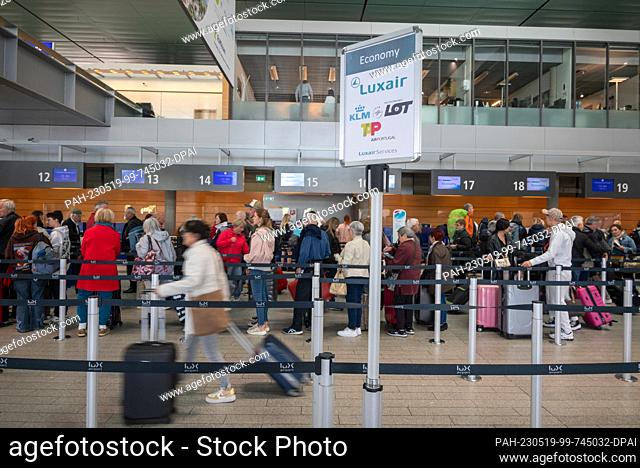 16 May 2023, Luxembourg, Luxemburg: Passengers stand with their luggage at a departure counter at Luxembourg's Findel Airport