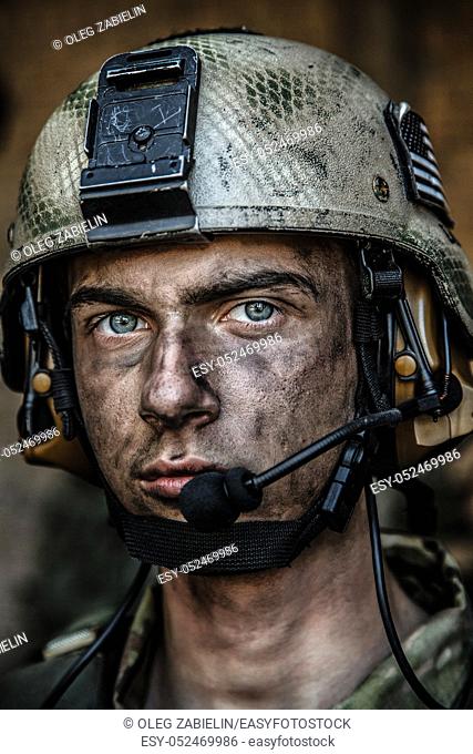 Smoked face of US Army Ranger wearing combat helmet. Closeup portrait. Bright eyes of soldier, young boy at war, sacrifice concept