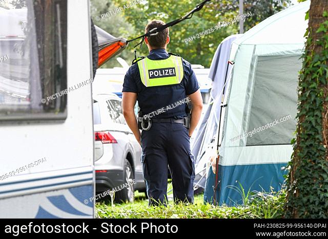 25 August 2023, Bavaria, Lindau: A police officer stands at a campsite. The previous night, a severe thunderstorm had passed over the southwest