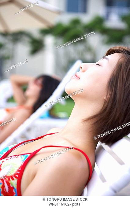 a bikinied woman lay on beach chair
