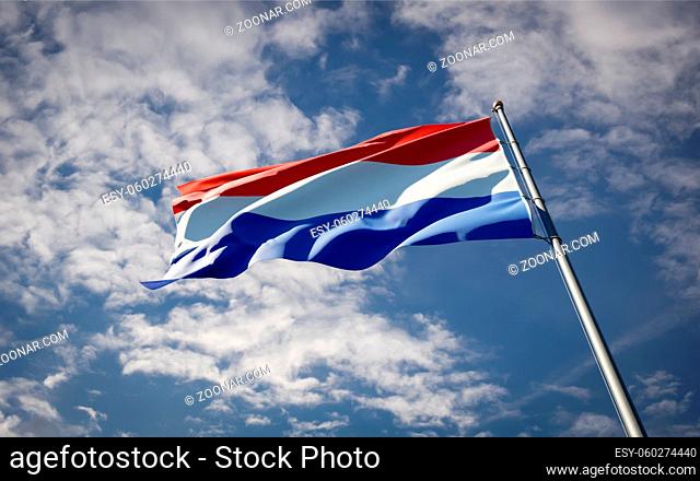Beautiful national state flag of Netherlands fluttering at sky background. Low angle close-up Netherlands flag 3D artwork