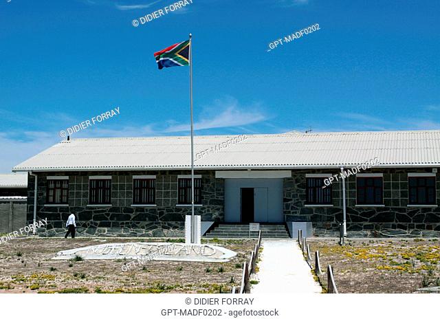 SOUTH AFRICAN FLAG IN FRONT OF THE ENTRANCE TO THE MAIN BUILDING OF THE FORMER PRISON WHERE NELSON MANDELA WAS HELD DURING APARTHEID, ROBBEN ISLAND, TABLE BAY