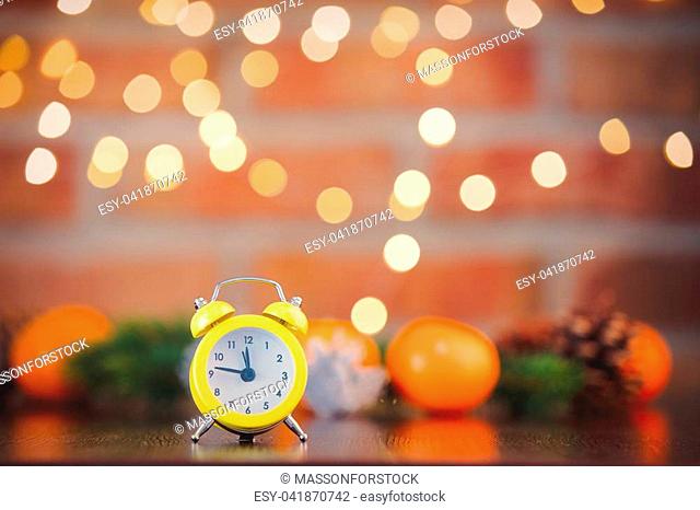 alarm clock on background with fairy lights in bokeh. Christmas Holiday season