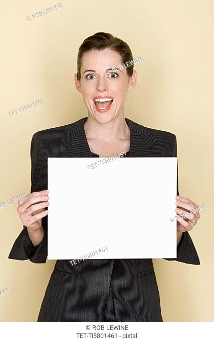 Portrait of happy mid adult woman holding blank sheet of paper