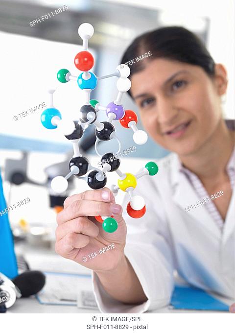 Female Asian using a molecular model to understand a chemical formula