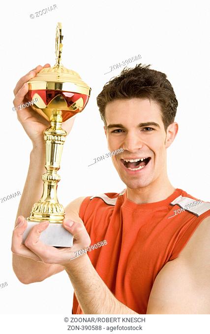 Junger Mann in Sportkleidung hält jubelnd einen Pokal nach oben