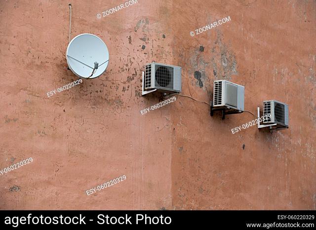 Air compressors of the air conditioner on the vintage wall, with satelite antena