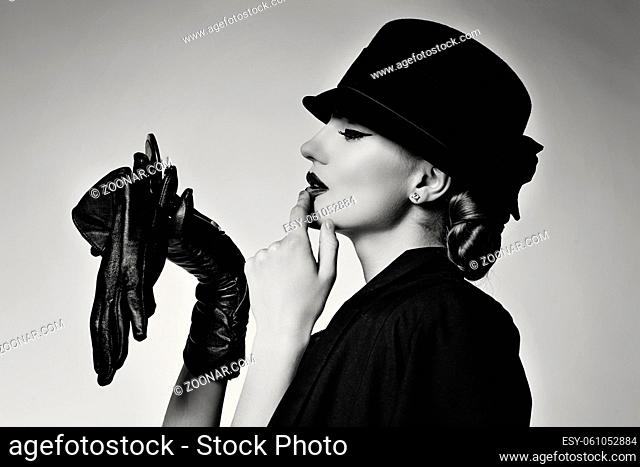 Retro beautiful young woman in black jacket and hat. Monochrome picture