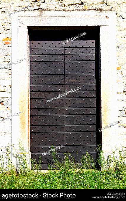 arsago seprio abstract  rusty brass brown knocker in a door curch closed wood italy lombardy