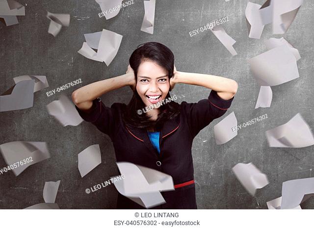 Beautiful asian business woman in stress with flying paper background
