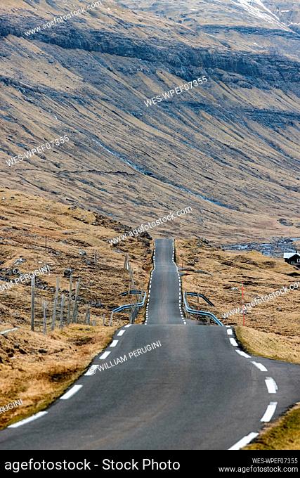 Empty road leading towards mountains, Faroe Islands