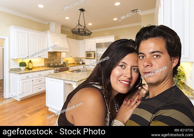 Affectionate hispanic couple inside custom kitchen interior