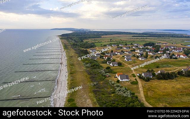 26 June 2021, Mecklenburg-Western Pomerania, Hiddensee: Houses stand in a meadow in Neuendorf. There are no roads or paths, only trails