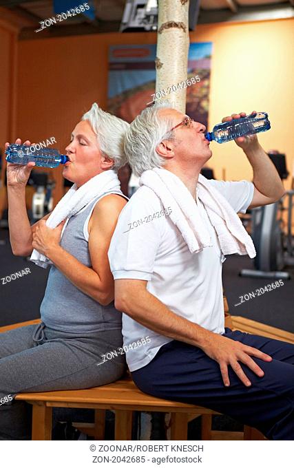 Old couple drinking water in the gym