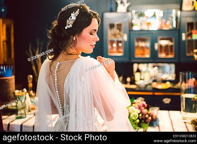 Beautiful bride with wedding makeup and jewelry crown. Bridal fashion posing in home. Morning of beautiful bride. Wedding day