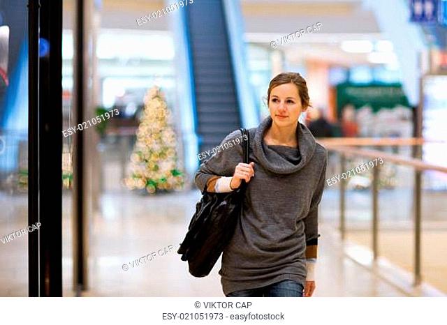 Young woman looking at store windows when shopping