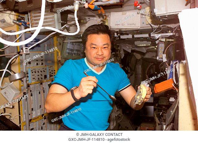 Astronaut Leroy Chiao, Expedition 10 commander and NASA ISS science officer, eats a meal in the Zvezda Service Module of the International Space Station (ISS)