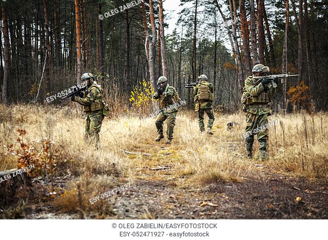 Norwegian Rapid reaction special forces FSK soldiers in field uniforms patrolling in the forest trees