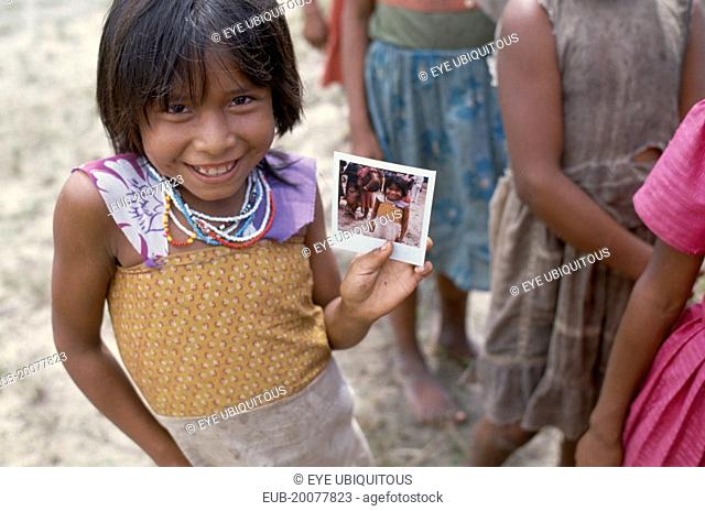 Macuna Indian girl holding a polaroid photograph of herself