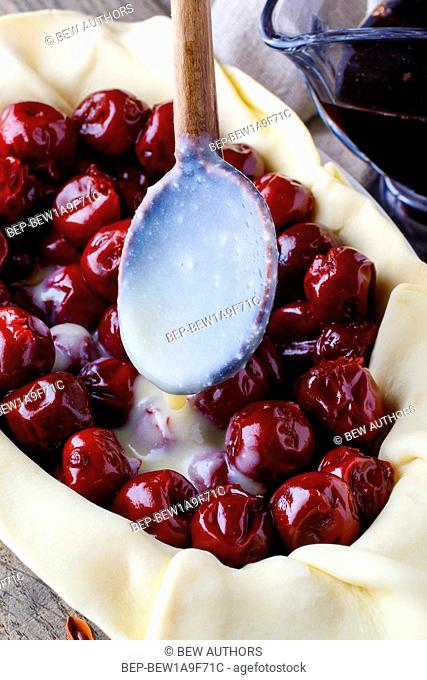 French puff pastry with cherries before baking. Party dessert