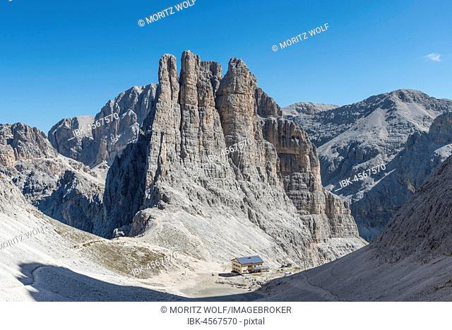 Descent from the Santner via ferrata, in front of Gartl hut, at the back climbing cliffs with Vajolett towers, Rosengarten group, Dolomites
