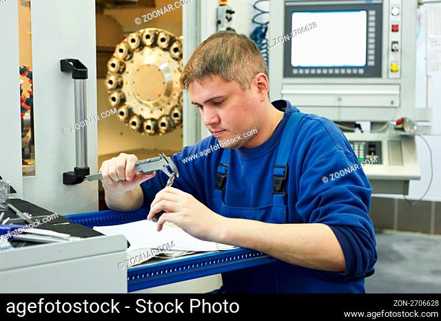 mechanical technician measuring detail after cnc milling cutting machine center at tool workshop