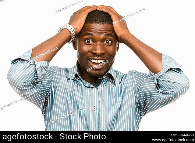 WoW gesture or omg emotion. Surprised Afro-American man feels positive shock. Young Amazed businessman holds his head with hands