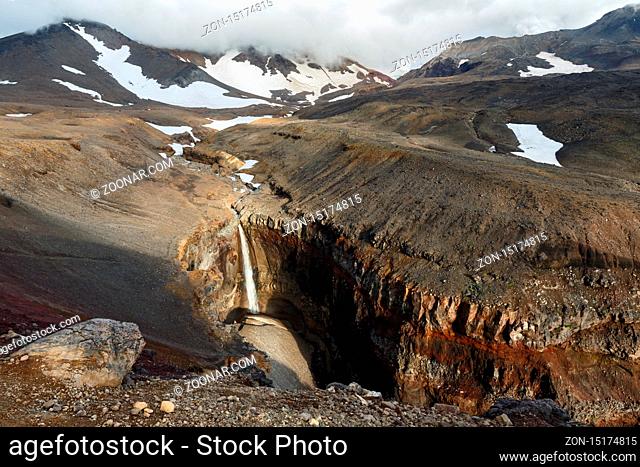 Beautiful landscape of Kamchatka Peninsula: view of Dangerous Canyon (Opasny Canyon), picturesque waterfall on the river Vulkannaya under the active Mutnovsky...