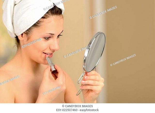 Woman doing morning routine applying lipstick
