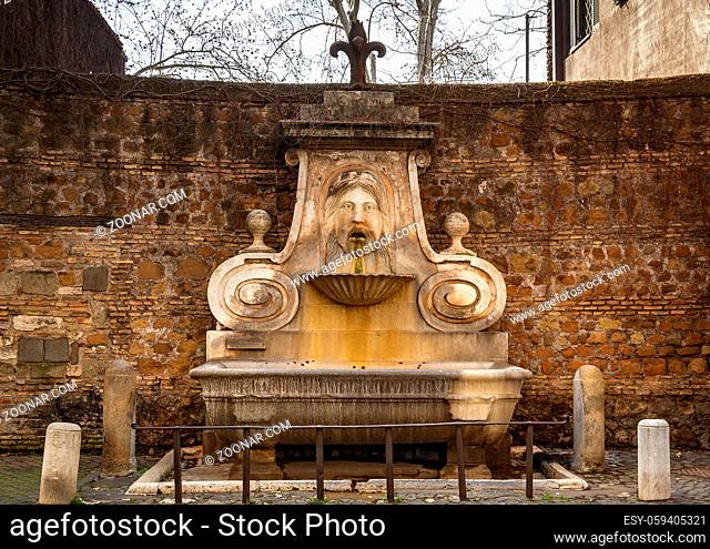 frontal view of the ancient Fountain of the Mask (fontana del mascherone) located in the ancient Via Giulia in Rome, Italy