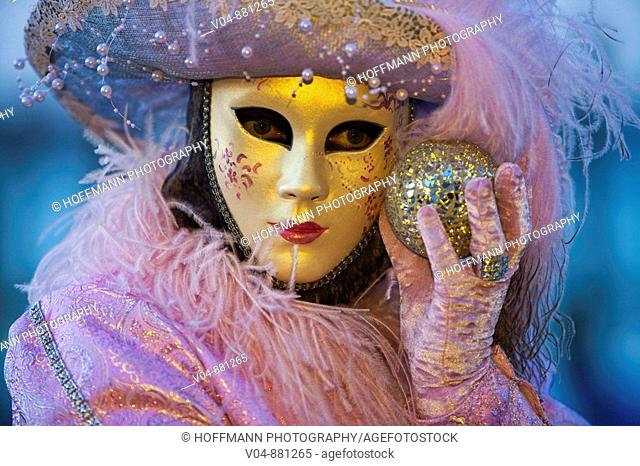 A masked woman holding a globe at the carnival in Venice, Italy, Europe