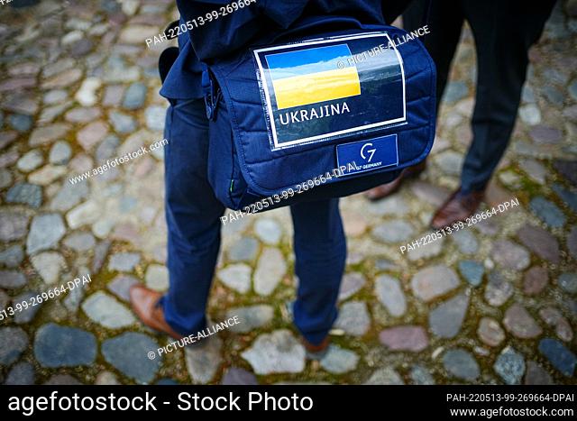 13 May 2022, Schleswig-Holstein, Weissenhäuser Strand: An employee carries a bag with the flag of Ukraine at the summit of foreign ministers of the G7 group of...