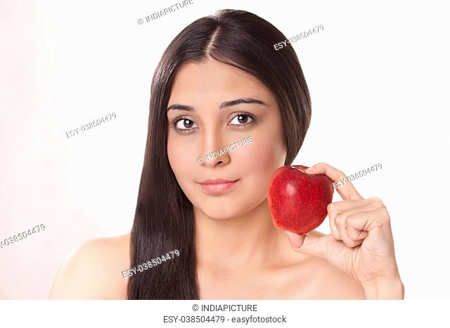 Portrait of young woman holding apple
