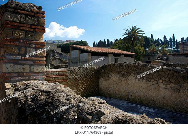 In the shadow of Vesuvius, the ruins of Ercolano - the Inn house, with modern town behind