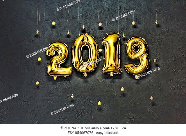 2019. Inflatable Gold Numbers on the Background of the Black Stone Wall New Year