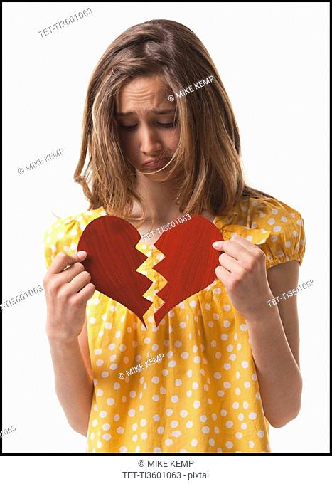 Teenage girl holding broken heart