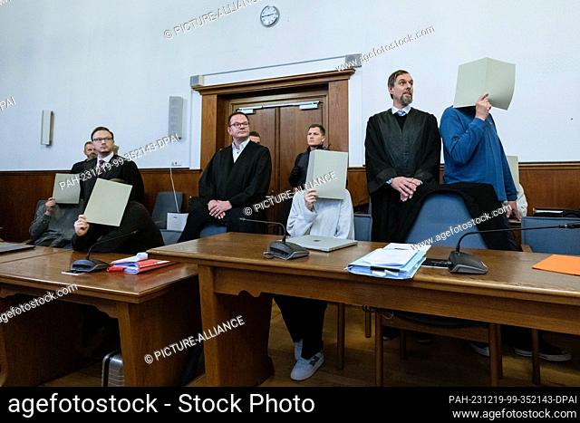PRODUCTION - 19 December 2023, North Rhine-Westphalia, Dortmund: The five accused police officers surrounding the shooter (2nd from left) sit between their...