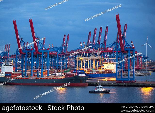 14 April 2021, Hamburg: Folded-up container gantry cranes are seen in the evening on the site of Hamburger Hafen und Logistik AG's (HHLA) Container Terminal...