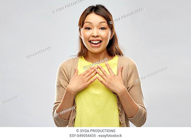 happy asian woman over grey background