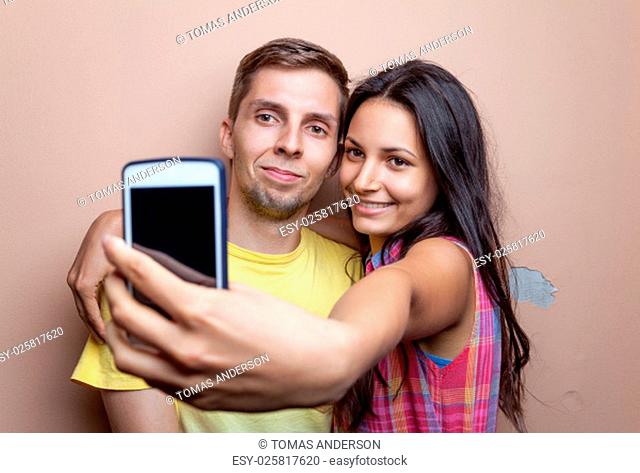 Young happy couple taking a selfie with mobile phone
