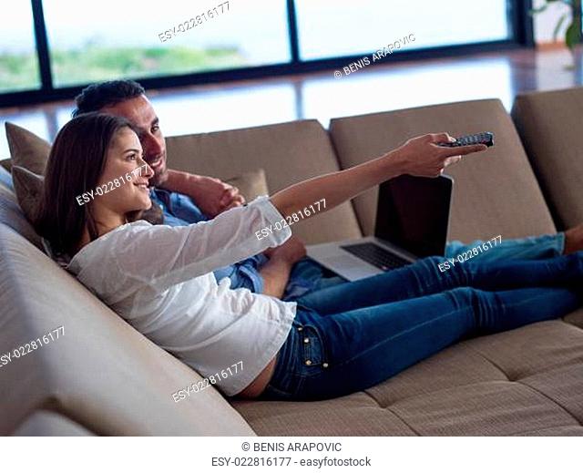 relaxed young couple working on laptop computer at home